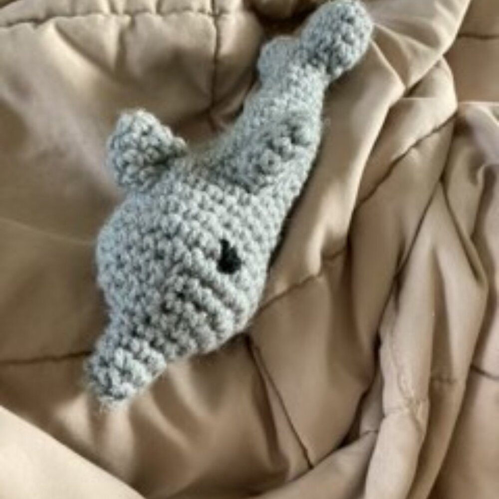 A gray handmade crocheted dolphin